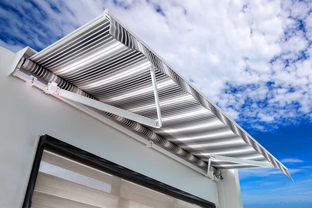 White and black striped awning on a cooky county home rijon manufactoring company